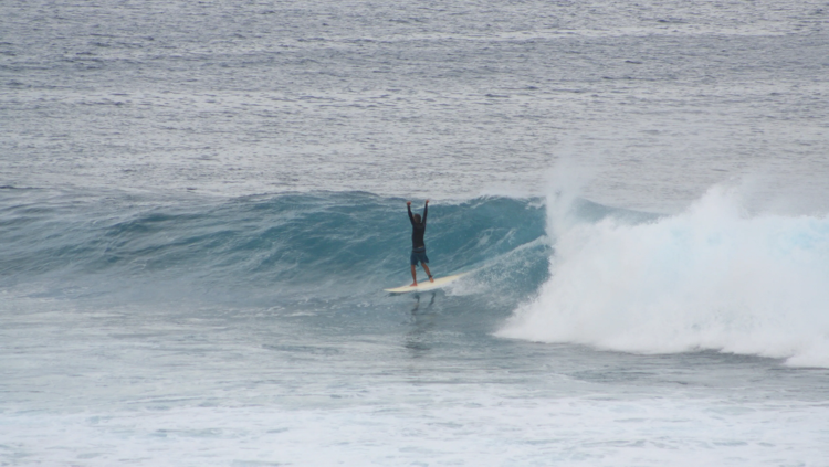 surfing a wave in guam
